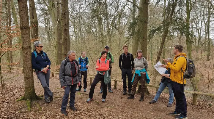 Naturwissenschaftlicher Vortrag von Johannes Aufgebauer während einer Wanderpause in einem Wald vor 8 Wanderern | © DAV Münster